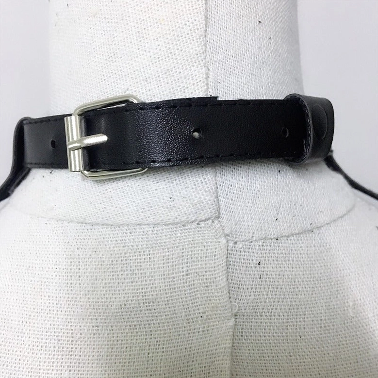 Alternative fashion black leather gothic harness featuring hollow-out geometric design, industrial metal accents, and tassel embellishments
