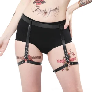 Black leather harness for women front view on tattooed model showcasing gothic aesthetic and adjustable body straps