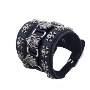 Gothic skull bracelet side angle showing rolled black leather strap with multiple antique silver skull charms and metal hardware details