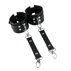 Black leather wrist cuffs with detachable silver D-ring connectors, flat lay front view showcasing snap clasps and rivets