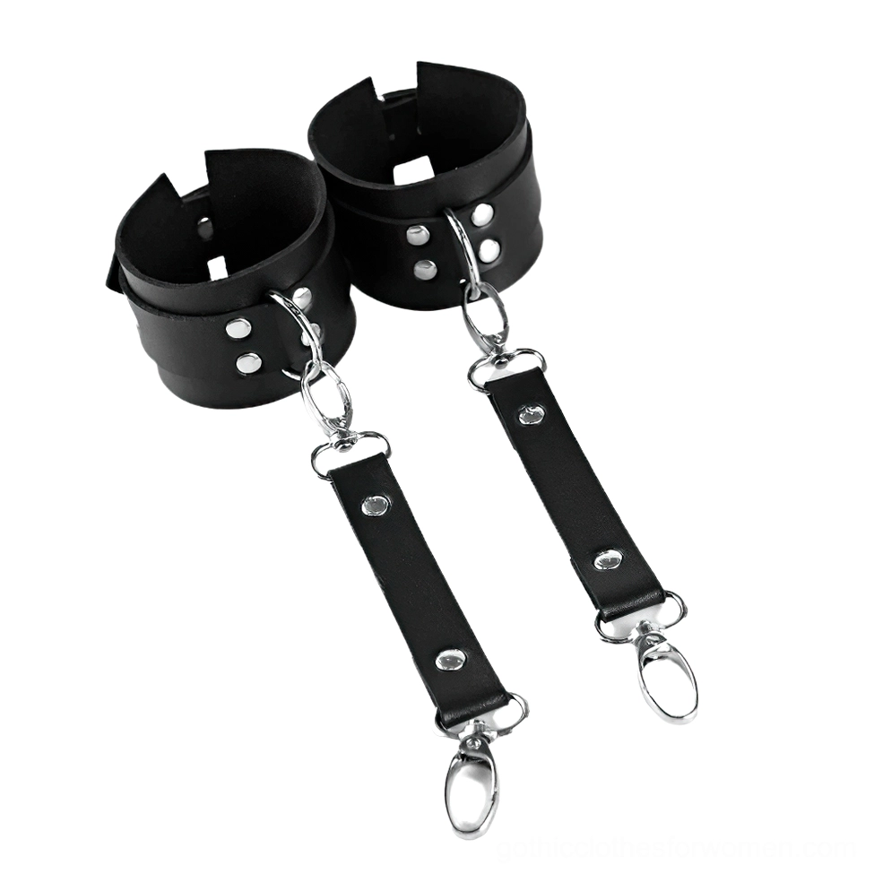 Black leather wrist cuffs with detachable silver D-ring connectors, flat lay front view showcasing snap clasps and rivets