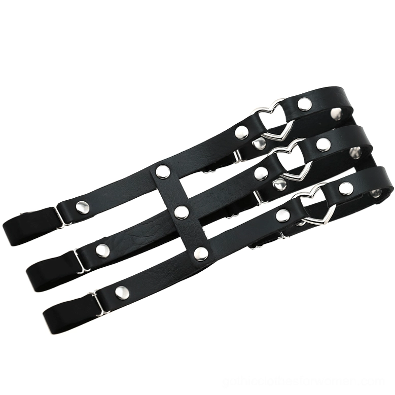 Detailed flat lay of black PU leather elastic leg harness with metal heart accents and rivet embellishments