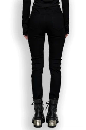 Black mesh grommet gothic skinny pants back view on model - slim fit silhouette with platform boots