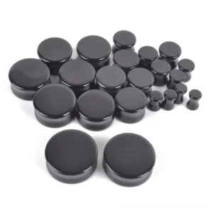 Front view of round black obsidian ear gauge plugs displaying the flat polished surface and deep black stone finish perfect for gothic style ear stretching