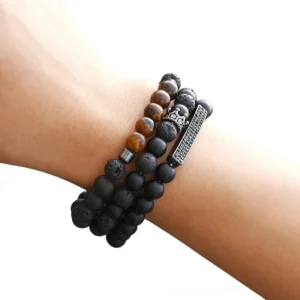 Black onyx beaded gothic bracelet with vintage crown charm on male wrist, matte stone beads close-up detail view