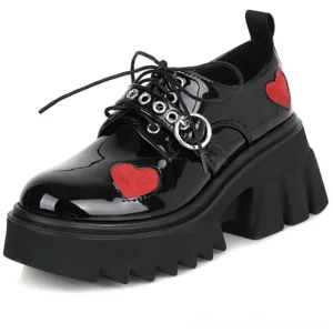 Black patent leather gothic platform pumps with red heart patches and silver metal hardware, front three-quarter view
