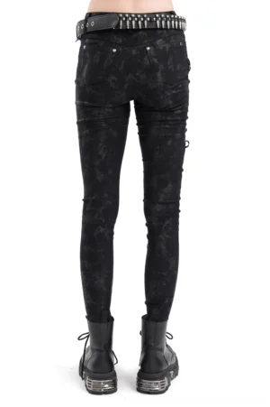 Rear view of black pentagram lace-up gothic skinny pants with skull studs and side lace details, modeled by woman with studded waist belt