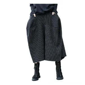 Front full-length view of black pinstripe gothic skirt on female model, featuring elastic waist and functional large side pockets
