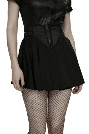 Black pleated mini skirt with rubber patch panel worn by model with green hair, paired with fishnet stockings and mesh crop top - front view