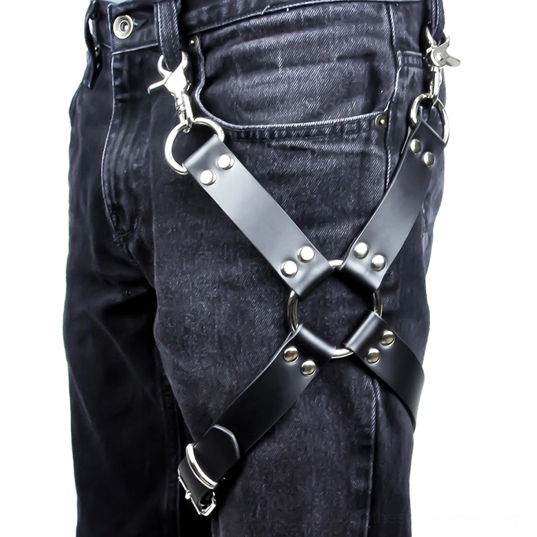 Black PU leather leg harness with cross straps and silver hardware worn over dark wash denim, front side view showing gothic bondage style