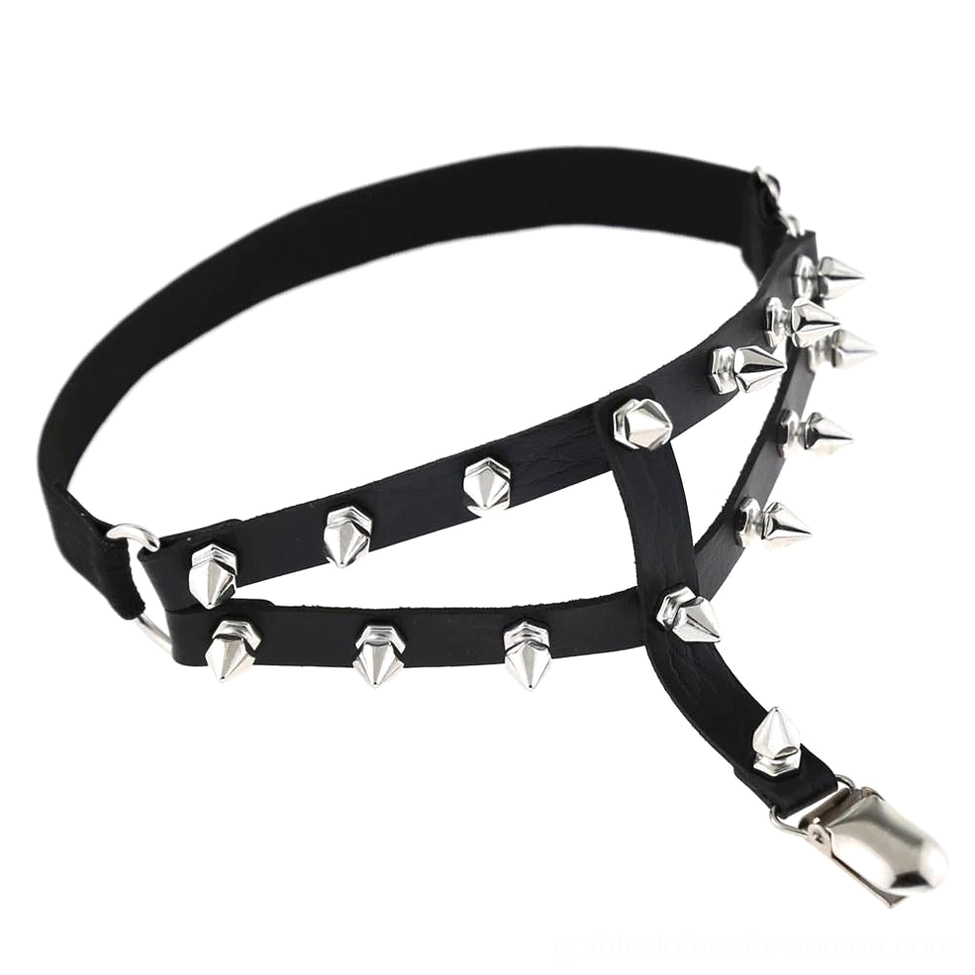 Black punk studded thigh garter harness flat lay showing adjustable buckle and cross strap construction