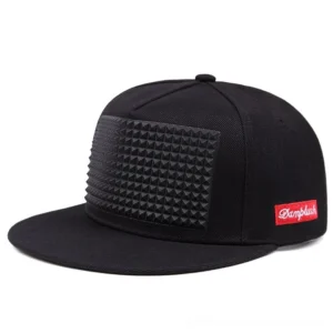 Black pyramid spike gothic baseball cap with flat brim, front-side view showing striking pyramid spike panel on crown