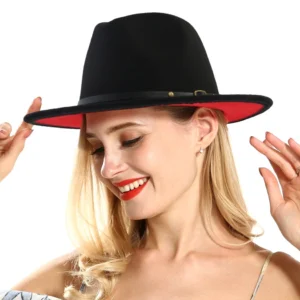 Black and red patchwork wool felt gothic fedora hat with leather belt and metal buckle, front three-quarter view on blonde female model