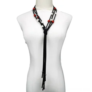 Black rubber cord gothic pearl lariat necklace with red and white pearls displayed on white mannequin - front view