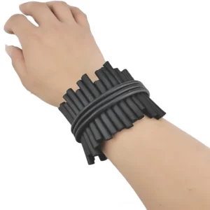 Black rubber gothic bangle worn on wrist, showing side profile of wide punk rock silicone bracelet with bundled stick design