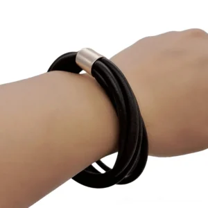 Black rubber multi-strand gothic bangle bracelet worn on female wrist with rose gold clasp, side close-up view