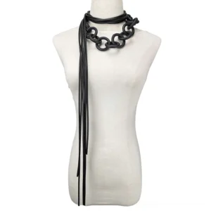 Black rubber gothic necklace with chunky chain and tassel cord worn on mannequin torso, front view studio shot