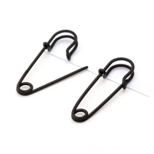Black matte safety pin cross ear stud earrings - gothic punk jewelry flat lay close-up