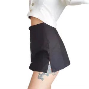 Black gothic mini skirt side profile showing high waist fit, safety pin decoration, and elegant a-line cut with side slit detail