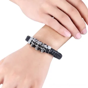 Braided black leather skull bracelet worn on wrist showing side profile with silver metal hardware and skull decorations
