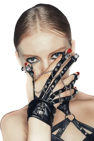 Woman wearing black gothic fingerless leather gloves with skull motifs, close-up hand portrait with dark makeup