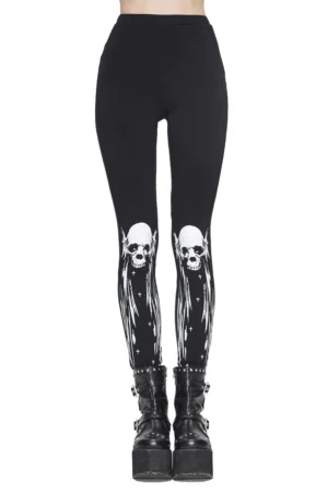 Front view of black gothic skull print leggings with white horned skull design on knees, modeled with platform boots