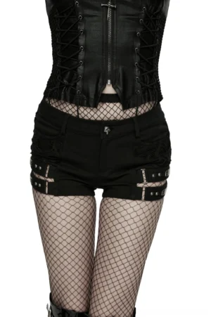 Black gothic punk cutout denim shorts with cross harness straps, front view on model wearing fishnet stockings