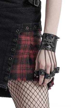Gothic punk leather hand glove bracelet with skull and spikes worn on female model against white background