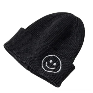 Black smiley face embroidered knit beanie with ribbed texture and outlined smiley logo, dark aesthetic winter hat front view