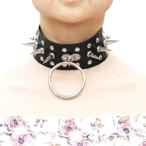 Black spike studded faux leather gothic choker necklace with metal O-ring pendant worn on female model neck, front close-up view against white background