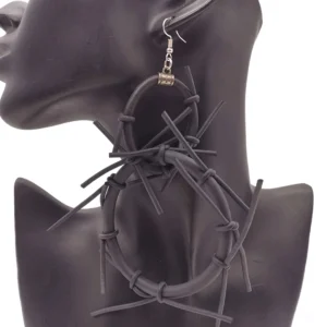 Black spike hoop earrings worn on female ear mannequin, left profile view showing dimensional silicone spikes and dark matte finish