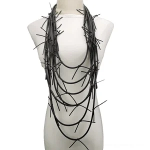 Black multi-layer spike rope necklace displayed on white torso mannequin, front view showing full layered Gothic pendant design with matte black finish