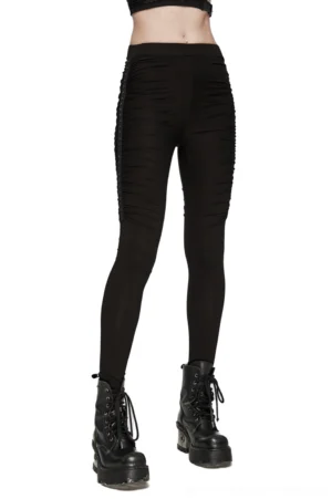 Black studded pleated gothic leggings styled with platform boots on female model, three-quarter view showing thigh ruching details and metallic studs