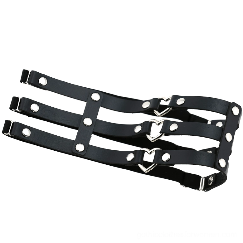 Flat lay overhead view of black synthetic leather leg harness showing silver rivets and heart-shaped fasteners