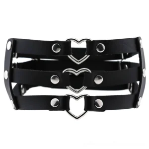 Black PU leather elastic leg harness with triple straps and silver metal heart decoration, front flat lay view