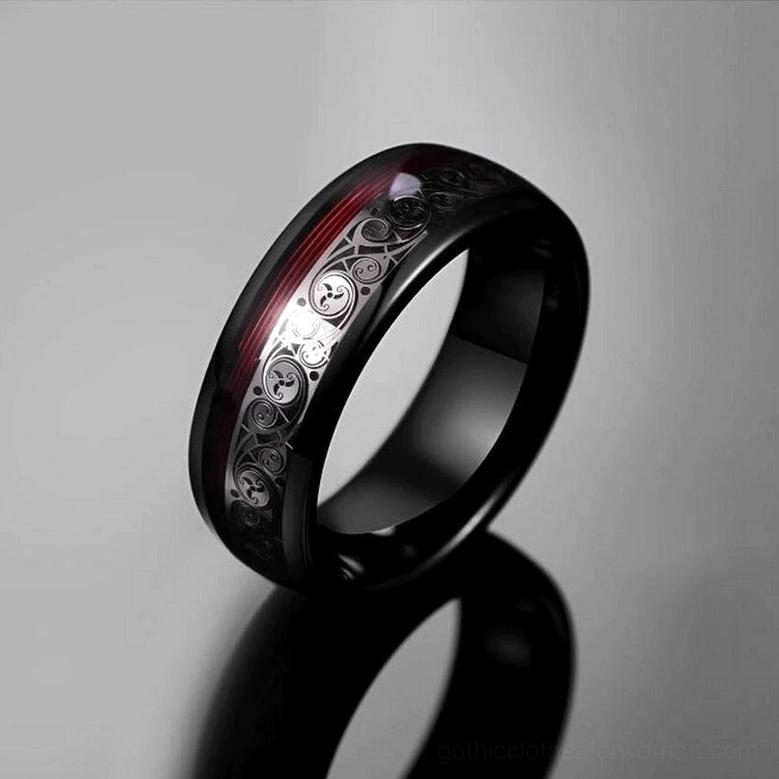 Black tungsten carbide alternative ring with silver folk pattern inlay and red decorative stripe, angled side view with reflection