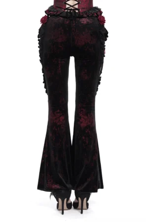 Rear view of gothic velvet flare pants featuring lace-up back closure and red rose decorations on black fabric