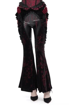 Black velvet gothic flare pants with red rose print and leather front panel, worn with black heels on model in studio setting