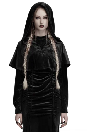 Black velvet hooded gothic cape with lace-up front worn by female model with braided hair, front three-quarter view showing dramatic drape and metal eyelet details