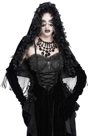 Black velvet hooded cape with rose floral trim worn by gothic model, front three-quarter view showing beaded fringe hem and ruffled hood details