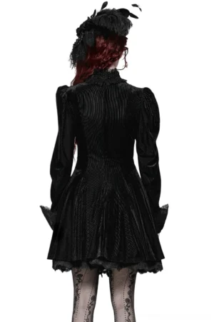 Gothic black velvet mini dress with ruffled high neckline and vertical texture detail shown from back view on red-haired model