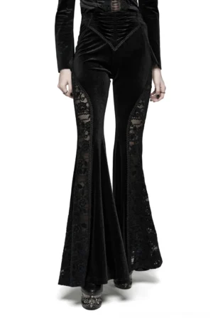 Black velvet gothic flared pants with lace side inserts worn by model in studio setting, front three-quarter view showing dramatic bell-bottom silhouette and intricate lace detailing