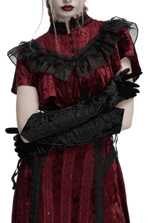 Gothic velvet arm gloves worn with black dress - three-quarter front view showing pointed cuffs and embroidery detail