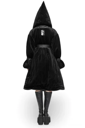 Black velvet gothic hooded long coat back view showing decorative patch detail, flared quilted cuffs, and dramatic draping on model