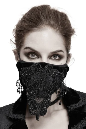 Black velvet gothic lace face mask with beaded appliqué worn by model, front close-up view