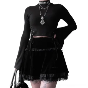 Black velvet gothic mini skirt with lace ruffles and inverted cross embroidery, full front view on model