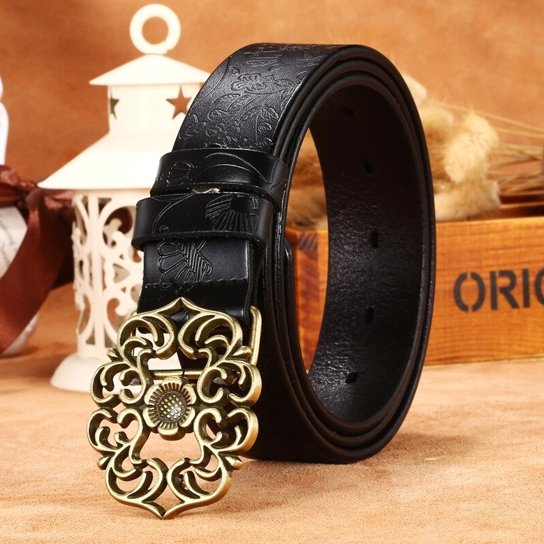 Black genuine leather gothic belt with embossed surface and ornate vintage bronze pin buckle in vintage decorative studio setting