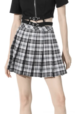 Black and white tartan pleated gothic mini skirt worn with black crop top and heart belt, front three-quarter view showing plaid pattern and pleated structure