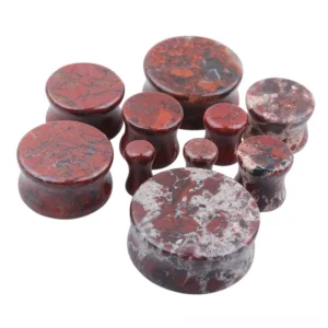Close-up detail of bloodstone ear gauge showing authentic marbled texture with crimson and grey-white veining, natural stone flesh tunnel jewelry