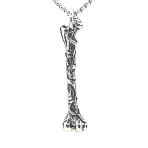 Carved bone stainless steel gothic pendant necklace overhead view with intricate floral engravings